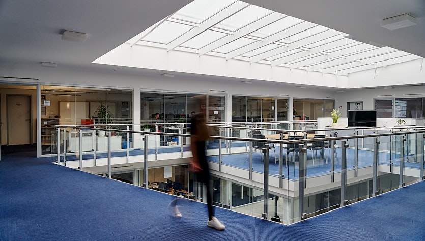 unscharfe Person läuft durch Galerie des ULT-Gebäudes