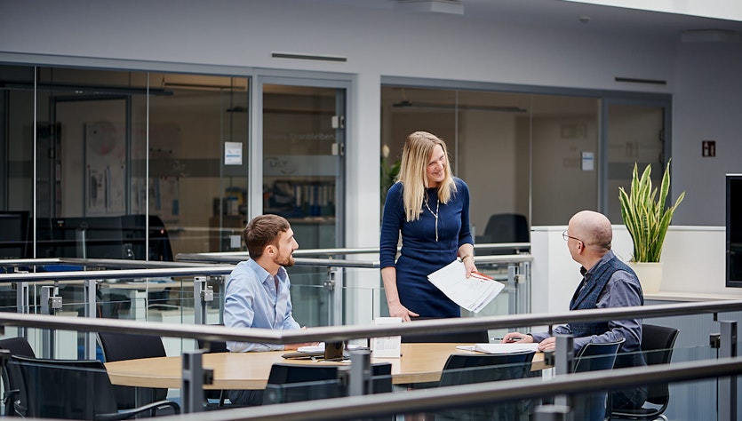 3 Personen sprechen auf der Galerie der ULT AG mitenander