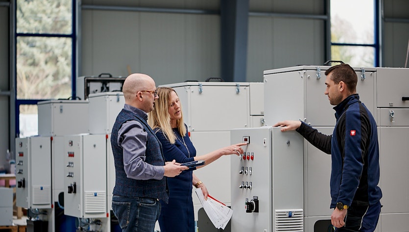 3 Personen stehen vor mehreren ULT-Geräten und besprechen sich
