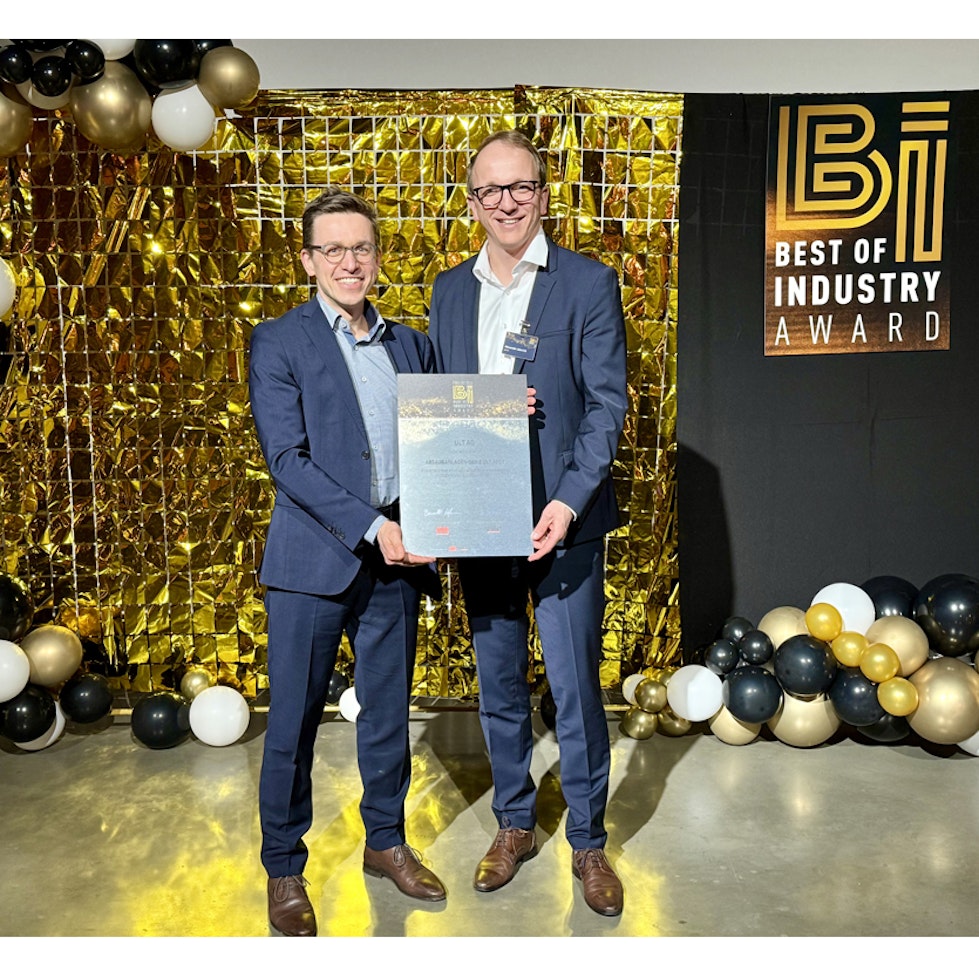 Zwei Männer im Anzug halten zusammen eine Urkunde in den Händen