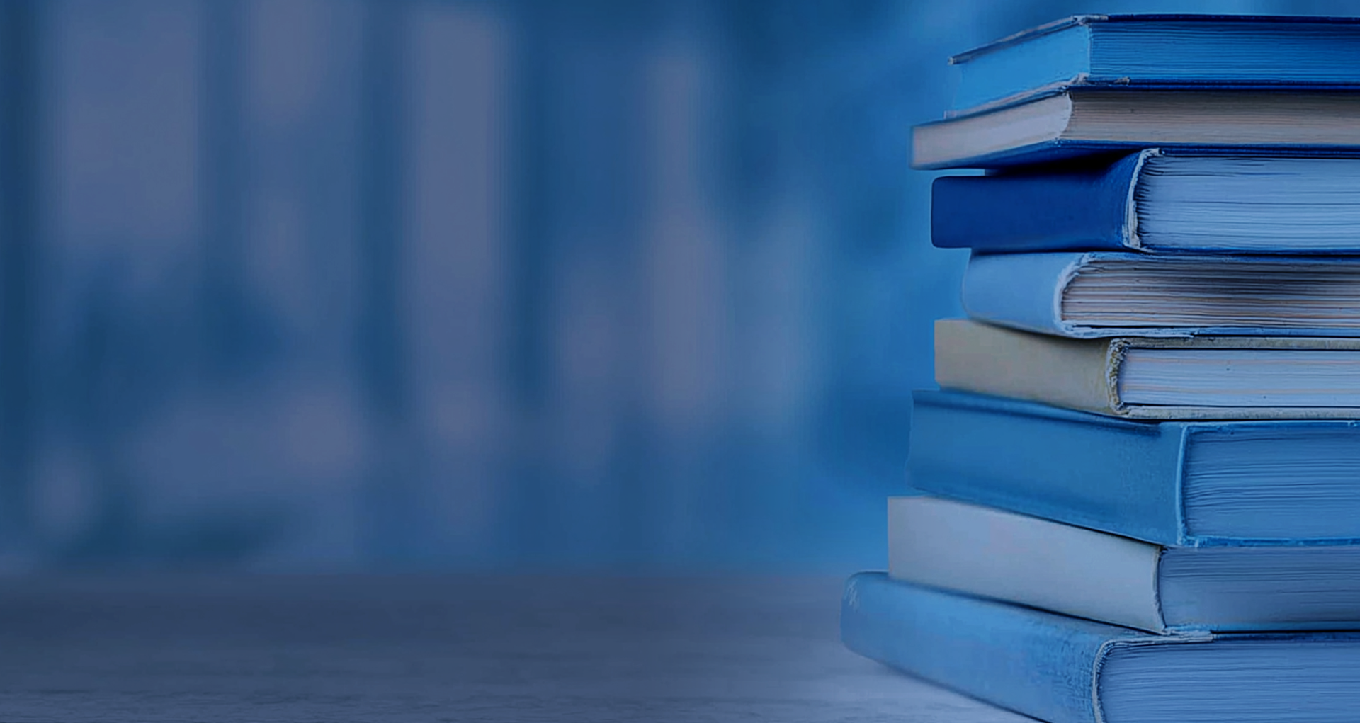 Mehrere Bücher übereinander gestapelt bei blauem Hintergrund