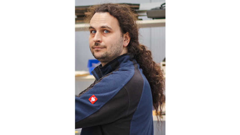 Junger Mann mit Dreitagebart und langen Haaren schaut nach links