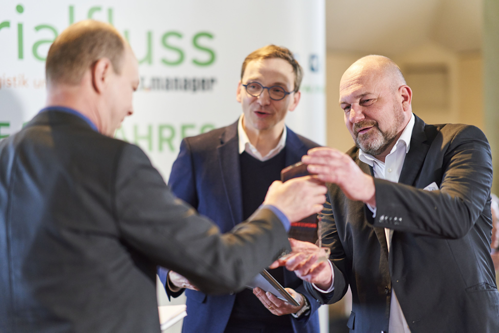 Ein Mann übergibt einem anderen einen Award