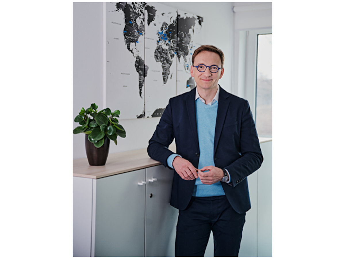 Junger Mann mit blauem Pullover unter dunkelblauer Anzugsjacke