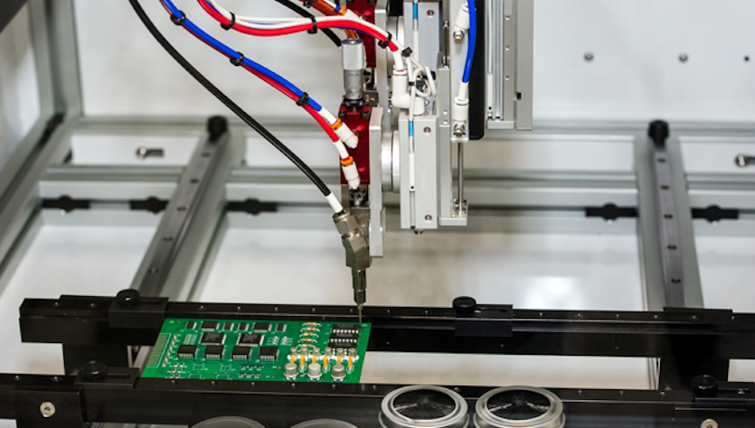 Dispenser trägt automatisiert Schutzlack auf einer bestückten Leiterplatte auf