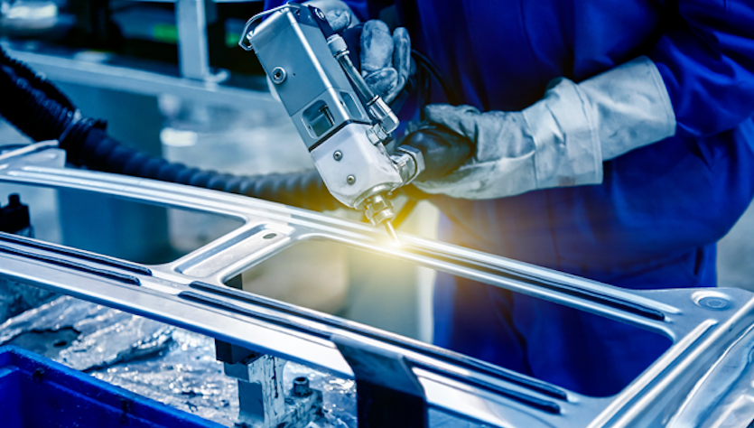 Worker applies adhesive to attach car windscreens