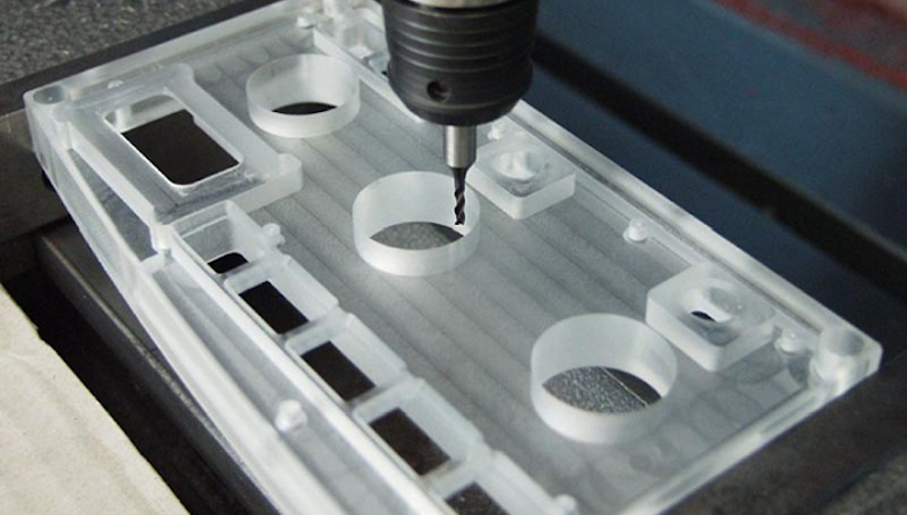 A milling cutter cuts a plastic part for automotive displays
