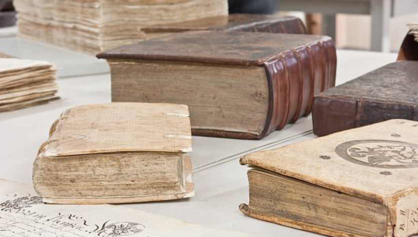 Zu restaurierende Bücher liegen auf einem Tisch