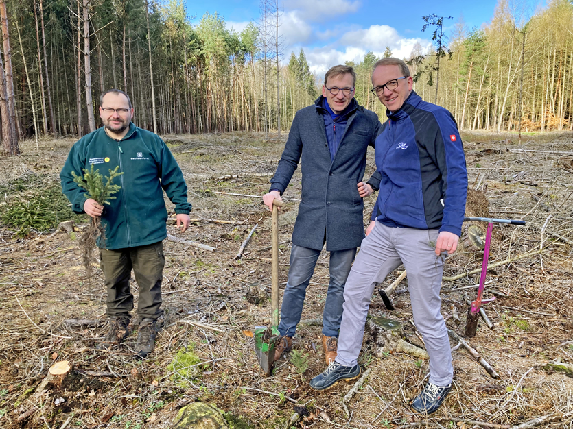 Three men in a wood looking into the camera