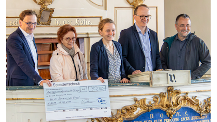 Fünf Menschen stehen vor der sanierungsbedürftigen Orgel