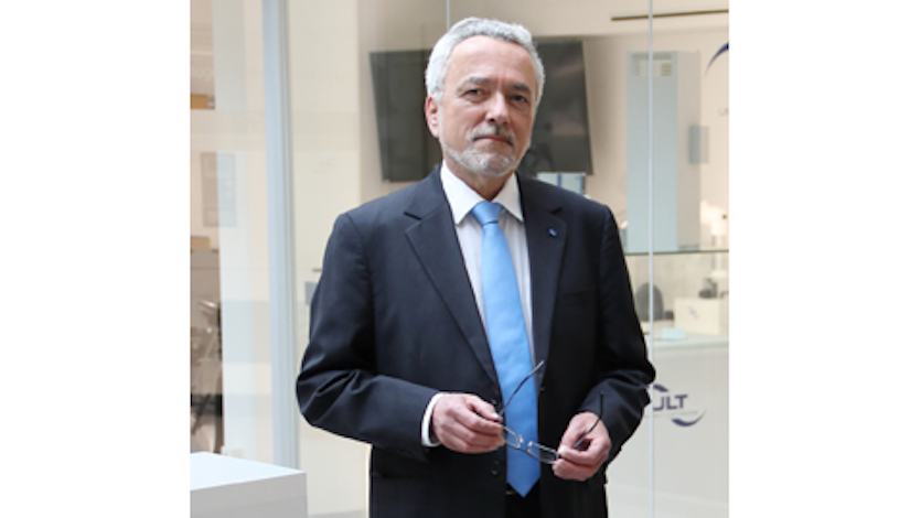 Mann mit Bart in Anzug und Schlips schaut in die Kamera